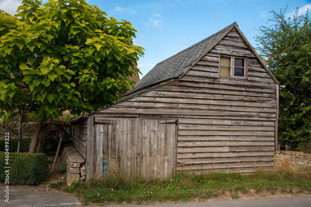 Guiting Power, Gloucestershire, England, UK. 2021. An old wooden barn with small garage doors in the rural Cotswolds village of Guiting Power. Guiting Power, Gloucestershire, England, UK. 2021. An old wooden barn with small garage doors in the rural Cotswolds village of Guiting Power.