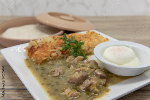 Loaded breakfast plate consisting of chile verde, hash browns, poached eggs, and flour torillas to fill your appetite