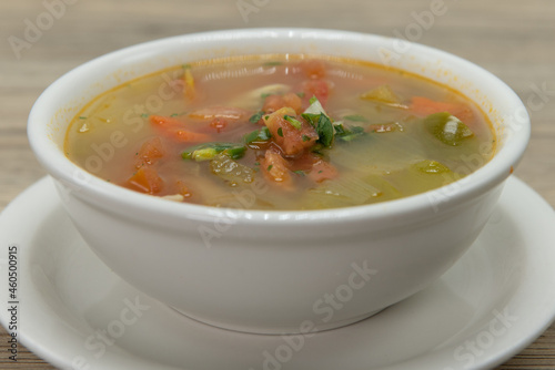 Soothing warm bowl of chicken vegetable soup on a saucer for a hearty meal