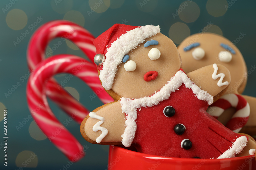 Delicious homemade Christmas cookies in cup against blurred festive lights, closeup