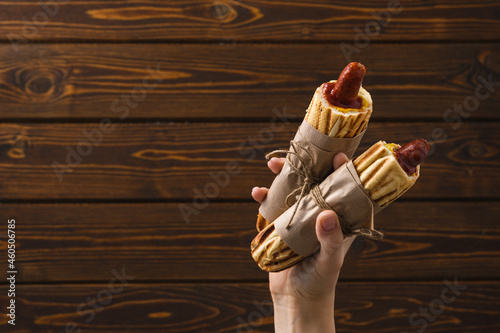 French hot dog in hаnd rustic style. Street food.