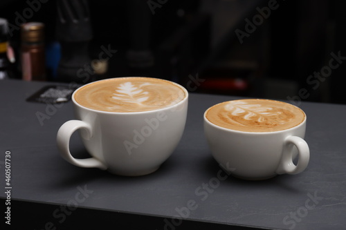 two cups of cappuccino on a gray bar counter