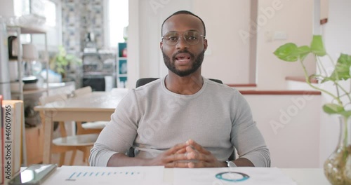 POV of African american businessman or male manager video conference meeting with co-worker, looking at camera and explain important project at living room while lockdown. Work from home concept.
