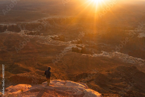 man hiking at sunrise in canyonlands national park in the summer in moab uath photo