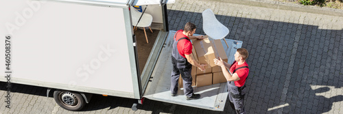 Male Movers Unloading The Cardboard Boxes Form Truck photo