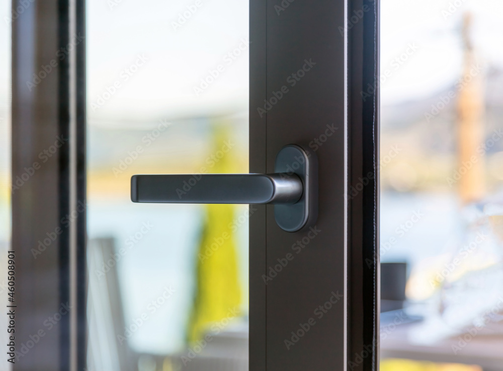 Aluminum door window close up, open glass frame with black handle, blur background Aluminum door window close up, open glass frame with black handle, blur background