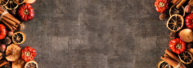 Autumn baking spices and ingredients. Double border on a dark stone banner background with copy space. Overhead view.