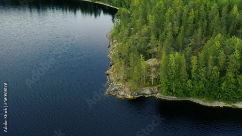 Aerial view of of small islands on a blue lake Saimaa. Landscape with drone. Blue lakes, islands and green forests from above on a cloudy summer morning. Lake landscape in Finland.	
