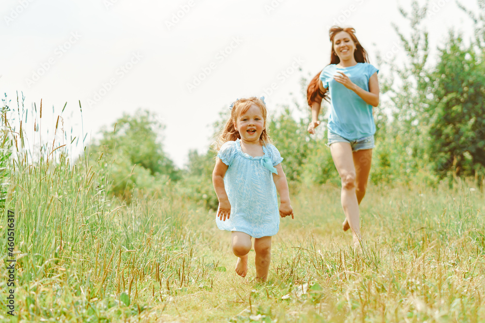 daughter runs towards her mother on the grass daughter runs towards her mother on the grass