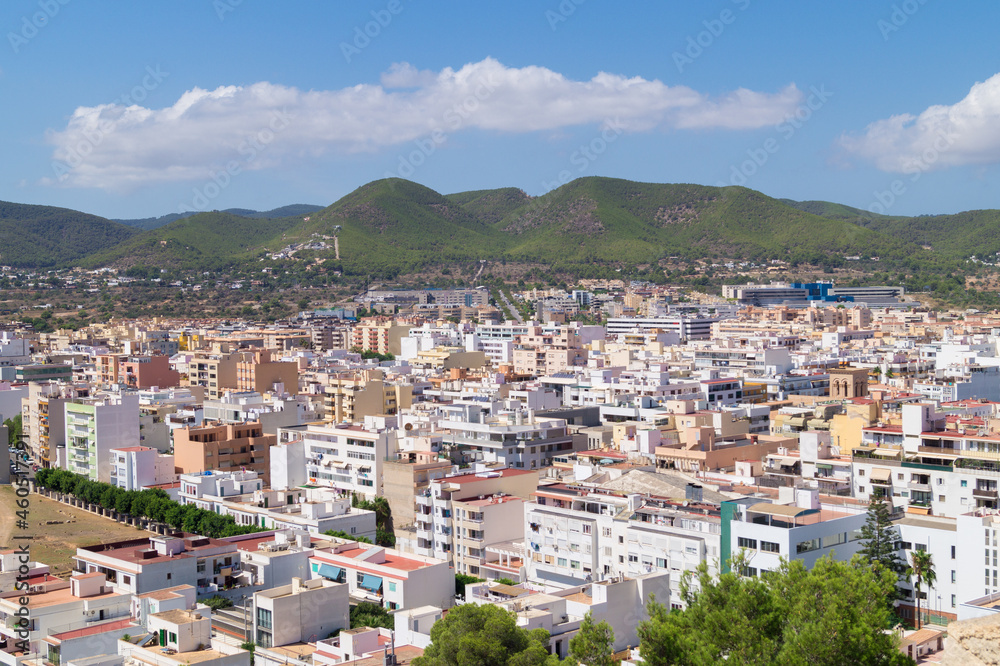 Views from above of Ibiza town (Balearic Islands, Spain). Landscape that contrasts the city in the foreground and the mountain in the background on a sunny day. 