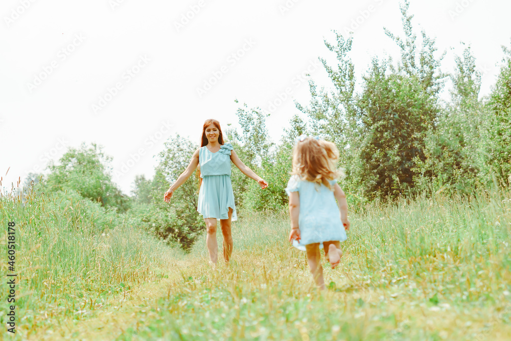 daughter runs towards her mother on the grass