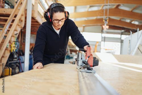 Fotografia Female carpenter or joiner at work in a woodworking factory