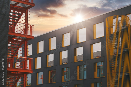 Bürogebäude mit Feuertreppe und Helikopter am sonnigen Himmel