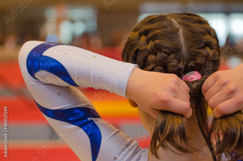 Valokuvatapetti Young gymnast girl fixing hair before appearance