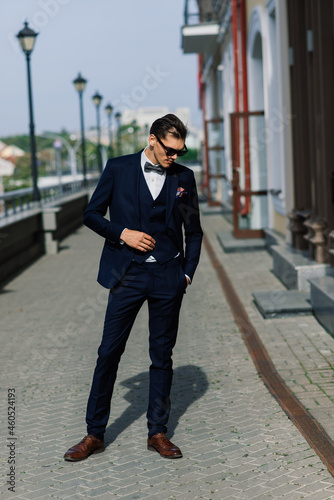 Portrait of an attractive young businessman in urban background wearing suit and a tie.