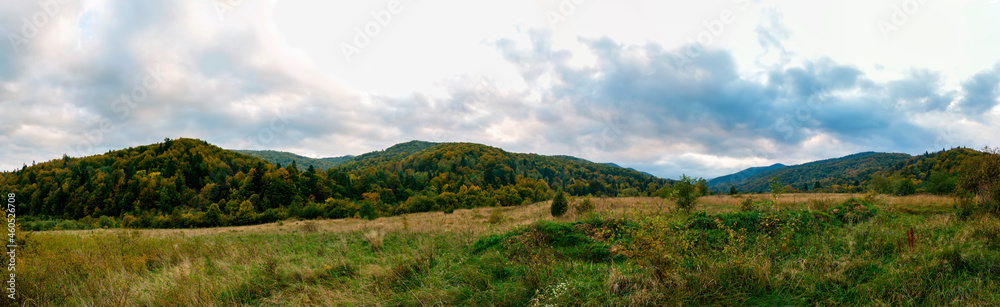Beautiful autumn panorama of yellow and red trees against the background of big mountains Beautiful autumn panorama of yellow and red trees against the background of big mountains