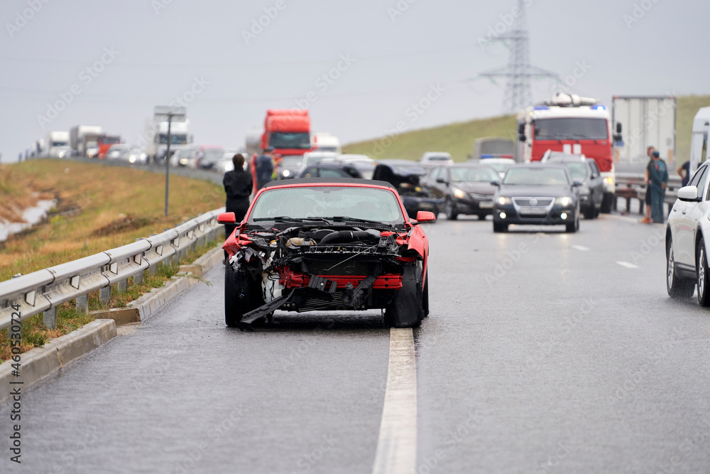 Collision on the motorway. In the foreground there are broken cars, in the background there is a traffic jam.