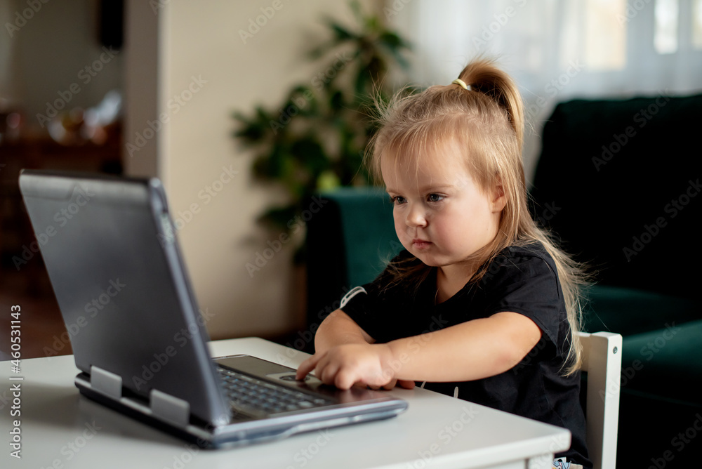 Cute little girl playing with plastic computer toy. Toddler with educational toys laptop for children Cute little girl playing with plastic computer toy. Toddler with educational toys laptop for children