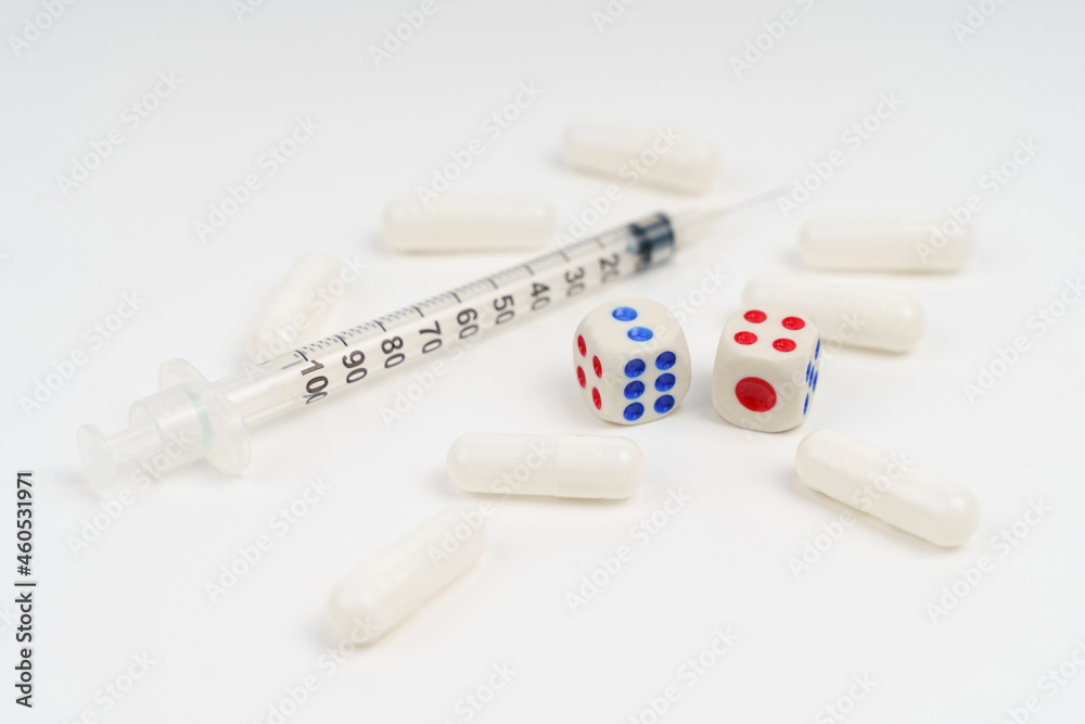 On a white background syringe, pills and dice. On a white background syringe, pills and dice.
