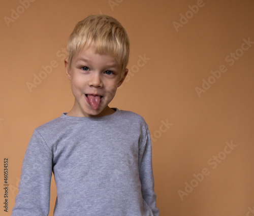 A boy is showing his tongue