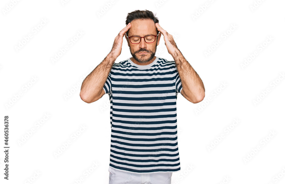 Middle age man wearing casual clothes and glasses with hand on head for pain in head because stress. suffering migraine. Middle age man wearing casual clothes and glasses with hand on head for pain in head because stress. suffering migraine.