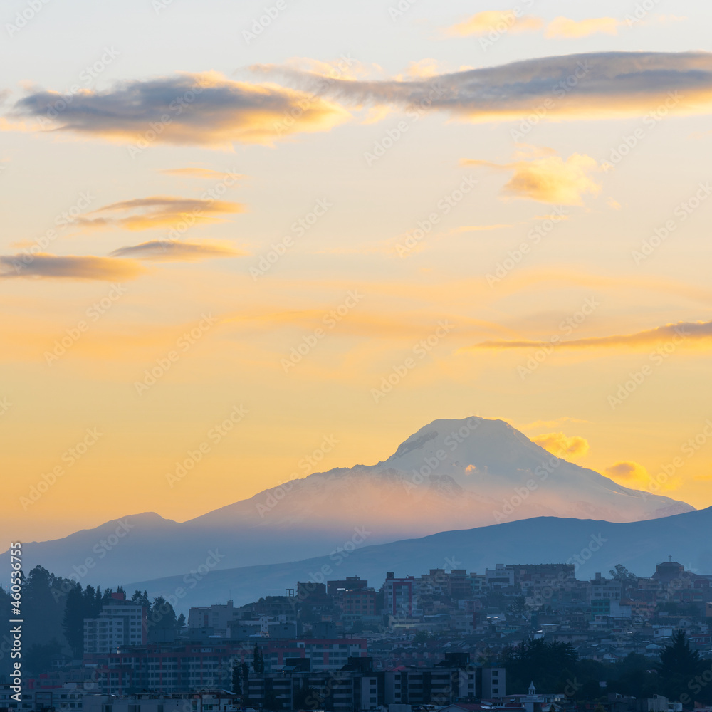 Cayambe volcano at sunrise in square format with Quito skyline, Ecuador.