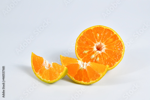 Half and slice of orange on white background.