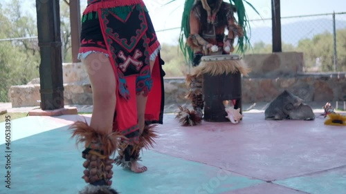 Dancer performing dance of pre-Hispanic culture with bright sky as background