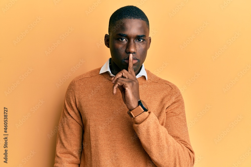 Young african american man wearing casual clothes asking to be quiet with finger on lips. silence and secret concept.