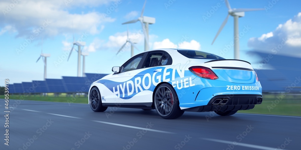 Hydrogen vehicle driving on a green road. Solar panels and wind turbines in the background. 