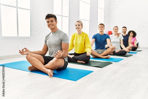 Group of young people smiling happy training yoga at sport center. © Krakenimages.com