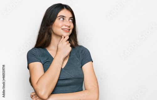 Young beautiful teen girl wearing casual crop top t shirt with hand on chin thinking about question, pensive expression. smiling with thoughtful face. doubt concept.