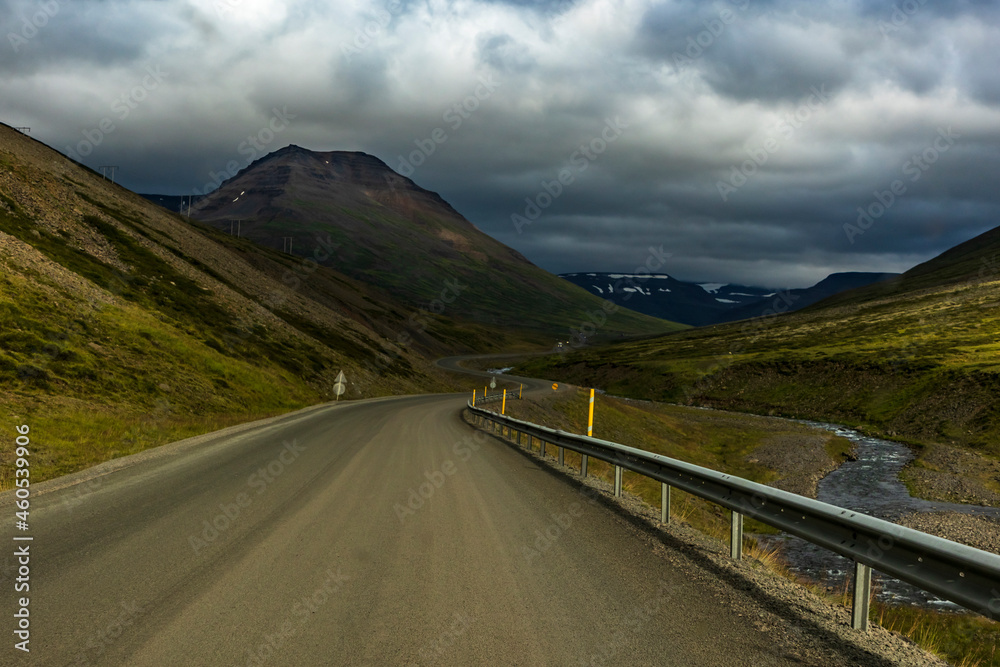 summer road trip on an open high way in Route 1 in Iceland with dramatic mountain landscape on the background.