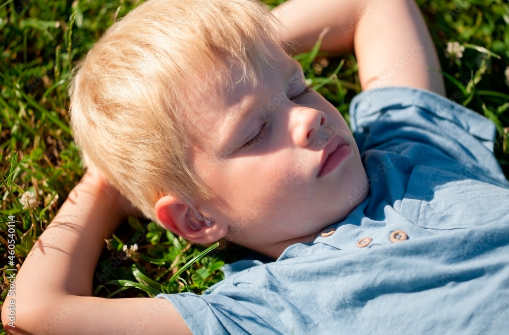Little beautiful kid outdoor. Lay on green grass. Little beautiful kid outdoor. Lay on green grass.