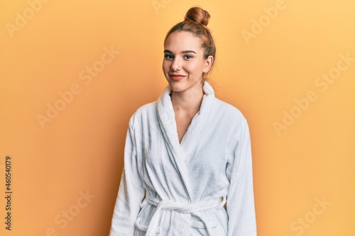 Young blonde woman wearing bathrobe with a happy and cool smile on face. lucky person. photo