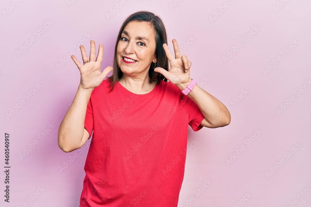 Middle age hispanic woman wearing casual clothes showing and pointing up with fingers number eight while smiling confident and happy.