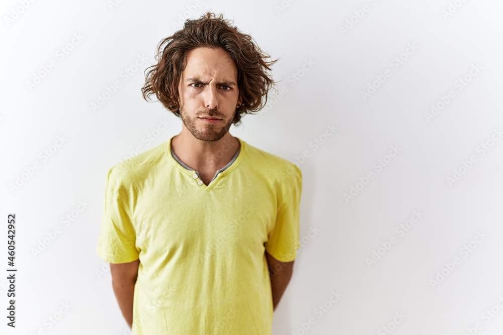 Young hispanic man standing over isolated background skeptic and nervous, frowning upset because of problem. negative person. Young hispanic man standing over isolated background skeptic and nervous, frowning upset because of problem. negative person.