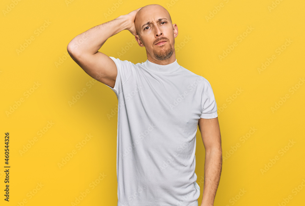 Bald man with beard wearing casual white t shirt confuse and wonder about question. uncertain with doubt, thinking with hand on head. pensive concept. Bald man with beard wearing casual white t shirt confuse and wonder about question. uncertain with doubt, thinking with hand on head. pensive concept.