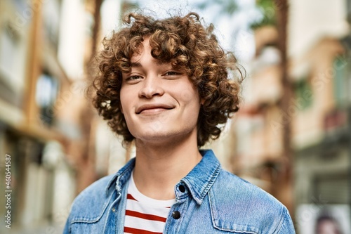 Young hispanic man smiling at the city