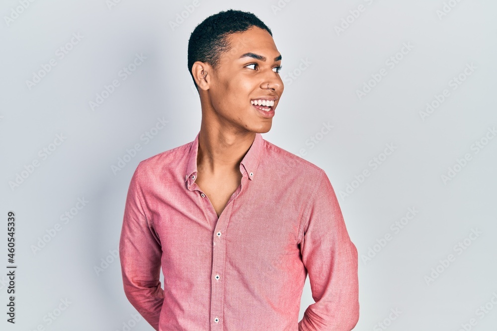 Young african american guy wearing casual clothes looking away to side with smile on face, natural expression. laughing confident. Young african american guy wearing casual clothes looking away to side with smile on face, natural expression. laughing confident.