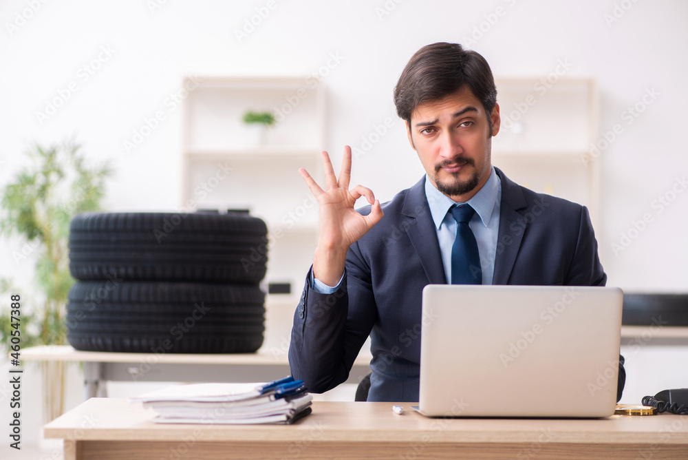 Young man selling tires in the office Young man selling tires in the office