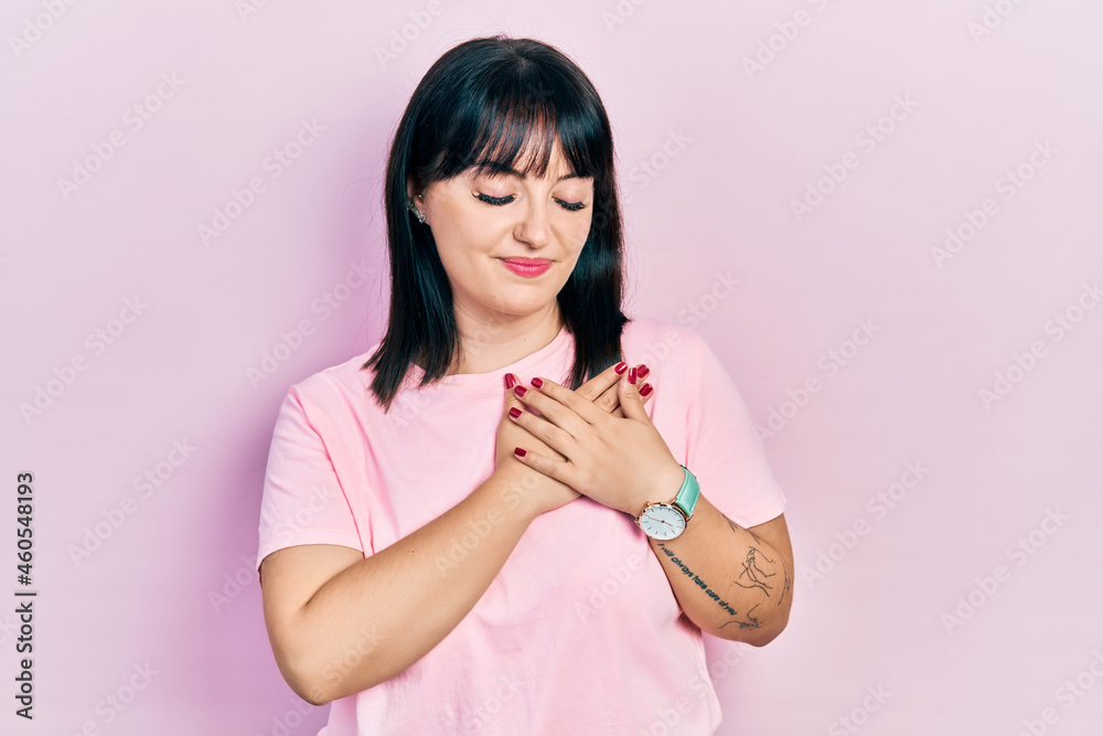 Young hispanic woman wearing casual clothes smiling with hands on chest with closed eyes and grateful gesture on face. health concept. Young hispanic woman wearing casual clothes smiling with hands on chest with closed eyes and grateful gesture on face. health concept.