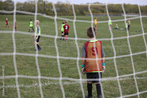 A young man plays goalie during a youth soccer game.