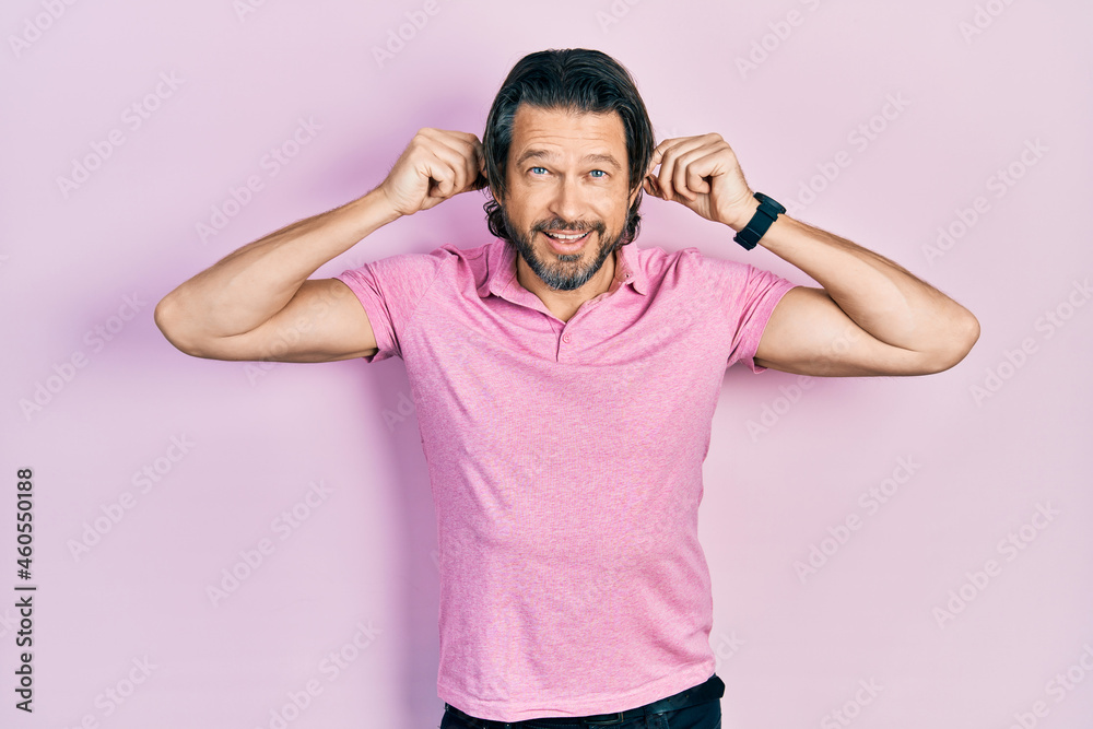 Middle age caucasian man wearing casual white t shirt smiling pulling ears with fingers, funny gesture. audition problem Middle age caucasian man wearing casual white t shirt smiling pulling ears with fingers, funny gesture. audition problem