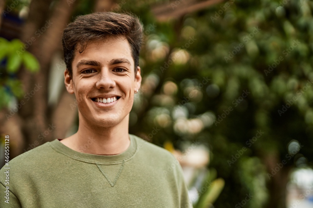Young hispanic man smiling happy standing at the city.