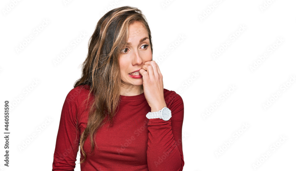 Young blonde woman wearing casual clothes looking stressed and nervous with hands on mouth biting nails. anxiety problem. Young blonde woman wearing casual clothes looking stressed and nervous with hands on mouth biting nails. anxiety problem.