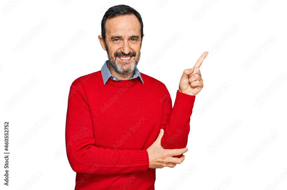 Middle age hispanic man wearing casual clothes with a big smile on face, pointing with hand and finger to the side looking at the camera. Middle age hispanic man wearing casual clothes with a big smile on face, pointing with hand and finger to the side looking at the camera.