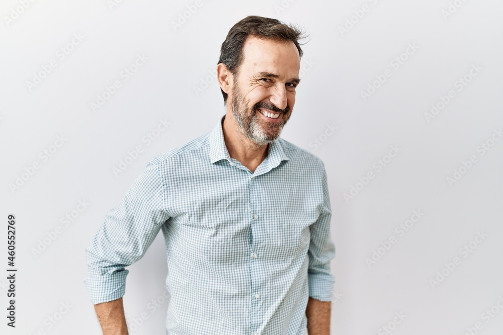 Middle age hispanic man with beard standing over isolated background looking away to side with smile on face, natural expression. laughing confident. Middle age hispanic man with beard standing over isolated background looking away to side with smile on face, natural expression. laughing confident.