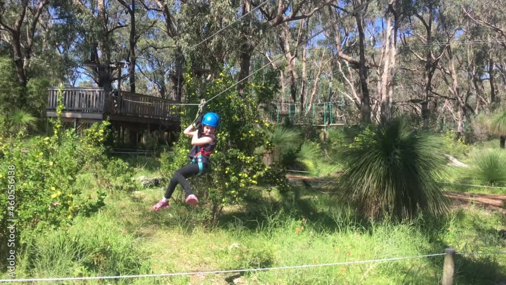 Young girl ride on a zip line in a forest Young girl ride on a zip line in a forest