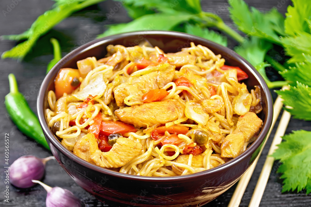 Noodles with cabbage and chicken in bowl on black board Noodles with cabbage and chicken in bowl on black board